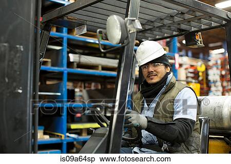 Stock Photography - Worker driving forklift in metal plant. Fotosearch