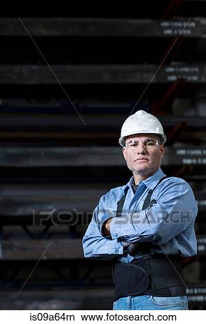 Picture - Worker in weight belt in metal plant. Fotosearch