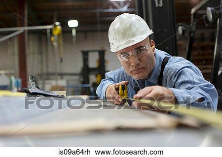 Worker measuring in metal plant View Large Photo Image Stock Image - Worker measuring in metal plant. Fotosearch
