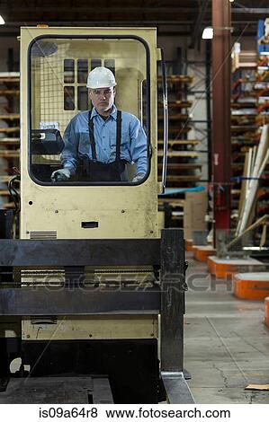 Stock Photo - Worker on forklift in metal plant. Fotosearch
