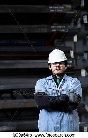 Worker standing in metal plant View Large Photo Image Picture - Worker standing in metal plant. Fotosearch