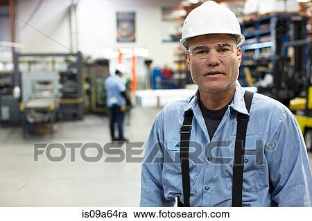 Worker standing in metal plant View Large Photo Image Stock Image - Worker standing in metal plant. Fotosearch