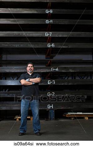Worker standing in metal plant View Large Photo Image Stock Image - Worker standing in metal plant. Fotosearch