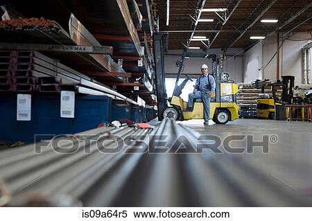 Worker standing in metal plant View Large Photo Image Stock Photography - Worker standing in metal plant. Fotosearch