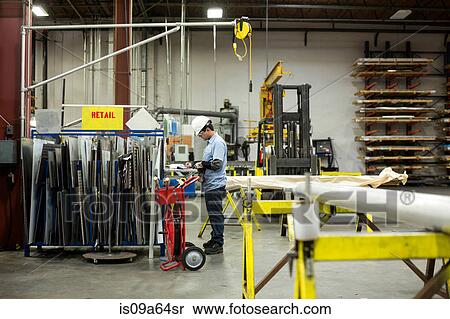 Worker standing in metal plant View Large Photo Image Stock Photography - Worker standing in metal plant. Fotosearch