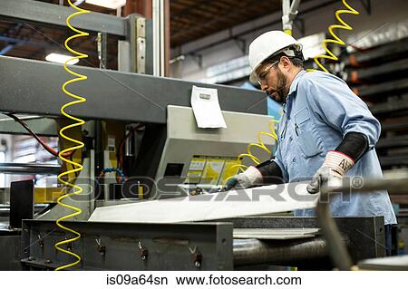 Worker using machinery in metal plant View Large Photo Image Picture - Worker using machinery in metal plant. Fotosearch