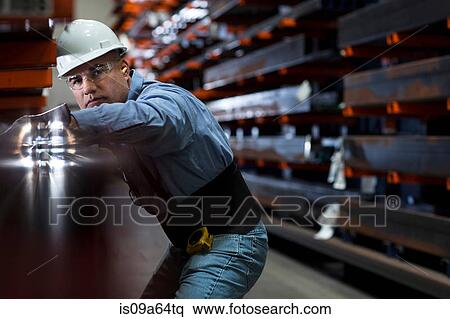 Stock Photography - Worker using machinery in metal plant. Fotosearch