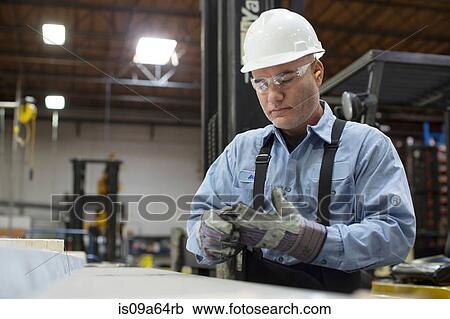 Stock Image - Worker with gloves in metal plant. Fotosearch