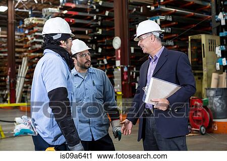 Stock Image - Workers and businessman in metal plant. Fotosearch