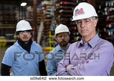 Stock Image - Workers and businessman in metal plant. Fotosearch