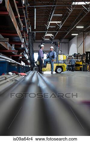 Picture - Workers talking in metal plant. Fotosearch