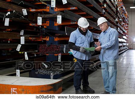 Stock Image - Workers talking in metal plant. Fotosearch