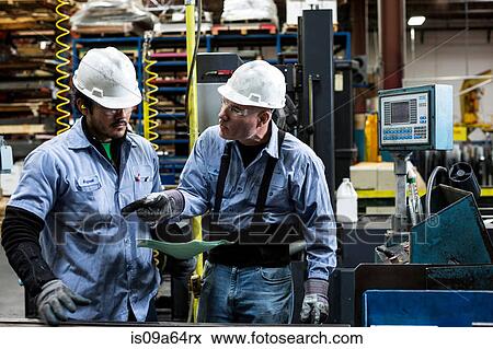 Stock Photo - Workers talking in metal plant. Fotosearch