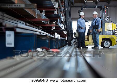 Stock Photograph - Workers talking in metal plant. Fotosearch