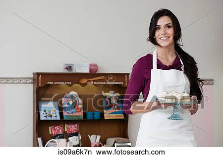 Baker holding tray of cupcakes View Large Photo Image Picture - Baker holding tray of cupcakes. Fotosearch