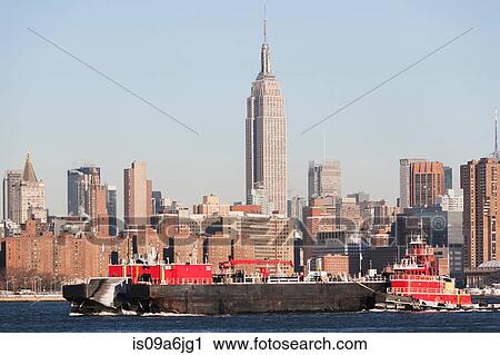 Barge floating by New York City skyline View Large Photo Image Stock Image - Barge floating by New York City skyline. Fotosearch