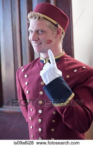 Bellhop smiling with kiss print on cheek View Large Photo Image Stock Photo - Bellhop smiling with kiss print on cheek. Fotosearch
