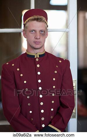 Stock Image - Bellhop with black eye in hotel lobby. Fotosearch
