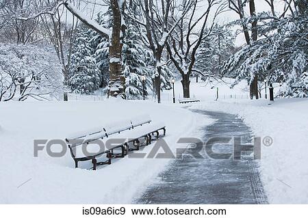 Stock Photo - Bench in snowy urban park. Fotosearch
