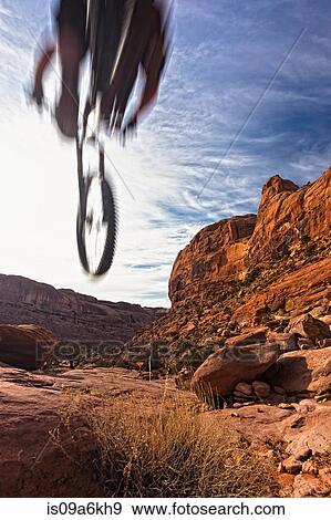 Stock Photo - Blurred view of mountain biker in air. Fotosearch
