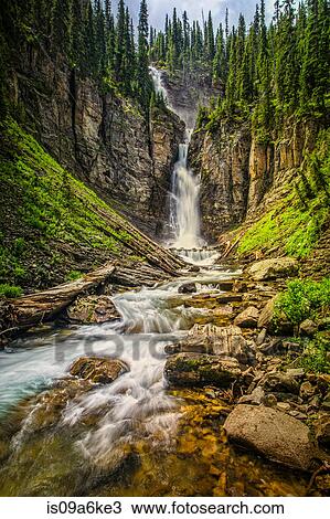 Stock Image - Blurred view of waterfall in canyon. Fotosearch