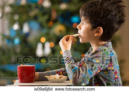 Stock Image - Boy eating Christmas cookies. Fotosearch