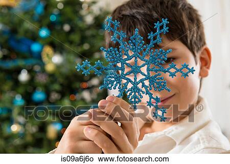 Boy holding blue snowflake decoration View Large Photo Image Picture - Boy holding blue snowflake decoration. Fotosearch