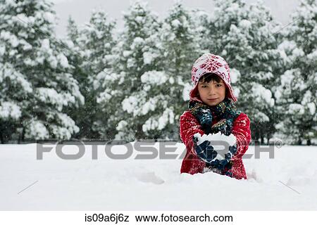 Stock Photo - Boy holding snowball outdoors. Fotosearch