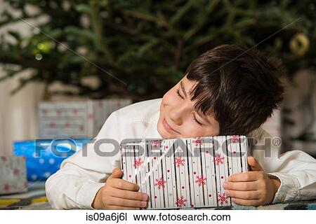 Boy hugging Christmas gift View Large Photo Image Stock Image - Boy hugging Christmas gift. Fotosearch
