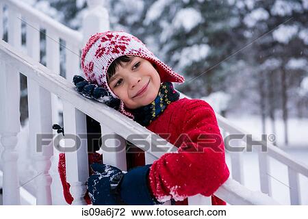 Stock Image - Boy hugging railing in snow. Fotosearch