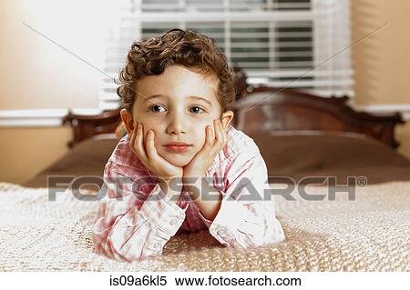 Boy laying on bed View Large Photo Image Stock Photography - Boy laying on bed. Fotosearch