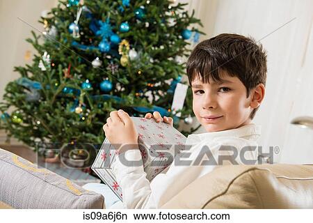 Picture - Boy opening Christmas gift. Fotosearch