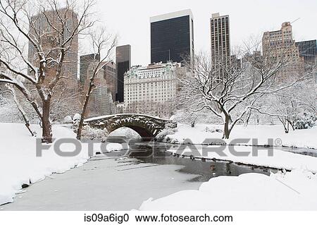 Stock Image - Bridge in snowy urban park. Fotosearch