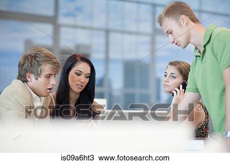 Stock Image - Business people talking at desk. Fotosearch