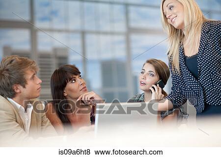 Stock Photo - Business people talking at desk. Fotosearch