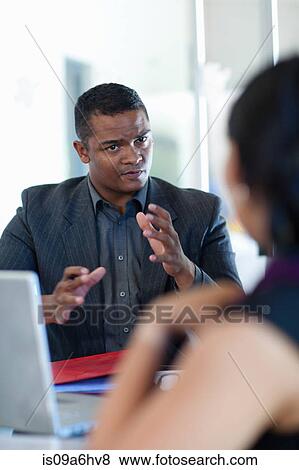 Stock Photo - Business people talking at desk. Fotosearch