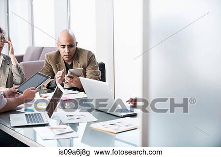 Stock Image - Business people working in meeting. Fotosearch