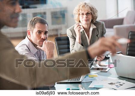 Stock Image - Businessman drawing graph in meeting. Fotosearch