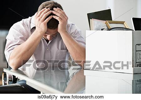 Stock Photo - Businessman packing up box in office. Fotosearch