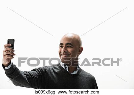 Businessman photographing self on cameraphone View Large Photo Image Stock Image - Businessman photographing self on cameraphone. Fotosearch
