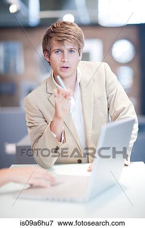 Businessman talking at desk View Large Photo Image Stock Photo - Businessman talking at desk. Fotosearch