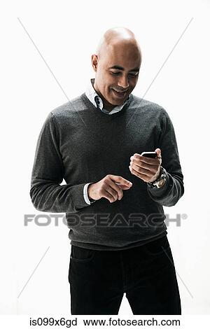 Stock Image - Businessman texting on smartphone. Fotosearch