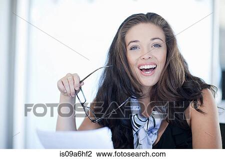Businesswoman holding glasses at desk View Large Photo Image Stock Image - Businesswoman holding glasses at desk. Fotosearch