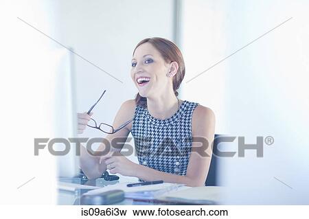 Stock Photo - Businesswoman laughing at desk. Fotosearch