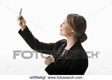 Businesswoman photographing self on cameraphone View Large Photo Image Stock Photograph - Businesswoman photographing self on cameraphone. Fotosearch