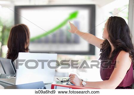 Stock Photo - Businesswoman pointing to graph. Fotosearch