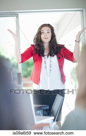 Stock Photo - Businesswoman shrugging in meeting. Fotosearch