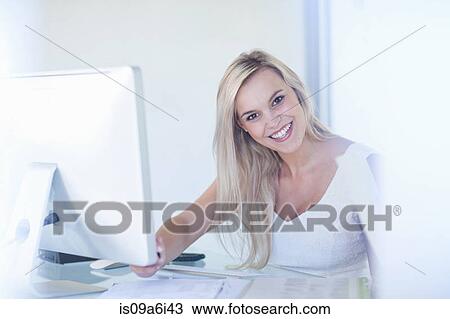 Businesswoman smiling at desk View Large Photo Image Stock Image - Businesswoman smiling at desk. Fotosearch
