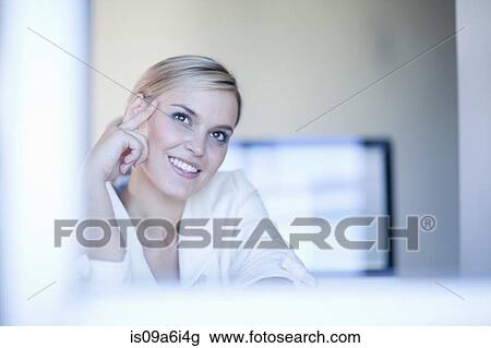 Businesswoman smiling at desk View Large Photo Image Stock Image - Businesswoman smiling at desk. Fotosearch