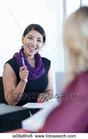 Stock Photograph - Businesswoman smiling in meeting. Fotosearch